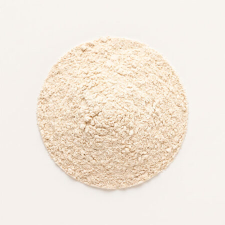 A top-down view of a circular mound of light beige powder on a plain off-white background